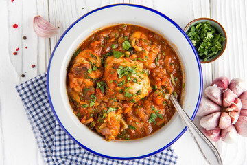 Chicken in tomato sauce with herbs and onions, cilantro parsley mint, traditional Oriental dish chakhokhbili, delicious homemade food.