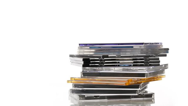 Software data or audio CDs stacked in stop motion over white - 4K UHD