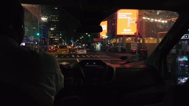 man driving across inner downtown Manhattan, New York, USA at night close to Times Square