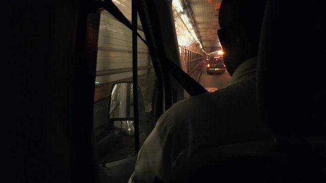 man driving across inner downtown Manhattan tunnel, New York, USA at night close to Times Square