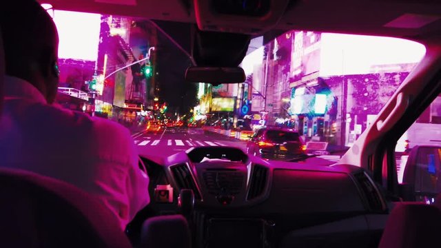 colorful cinematic footage of a man driving across inner downtown Manhattan, New York, USA at night close to Times Square