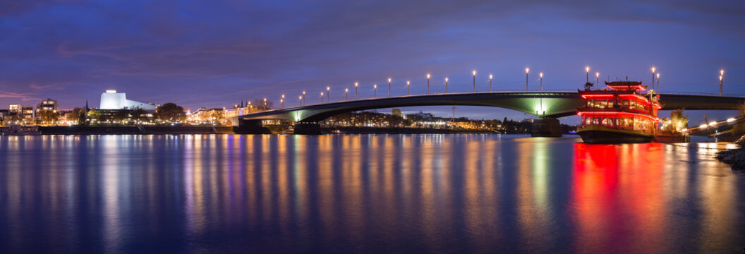 Panorama of the illuminated Kennedy Bridge and the river Rhine in blue hour after sunset in Bonn, Germany