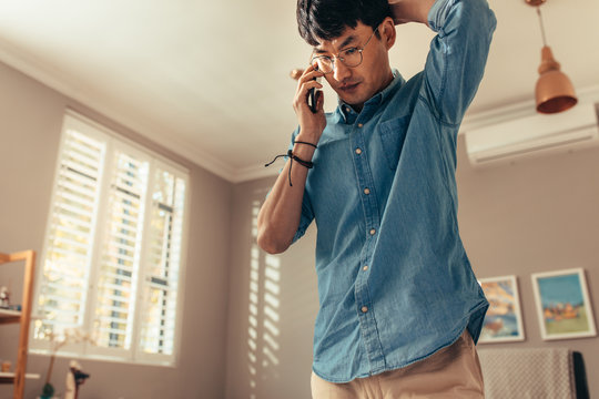 Man looking stressed while answering phone call
