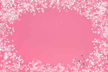 Pink holiday background with star glitter and bokeh. Top view, copy space. Flat lay