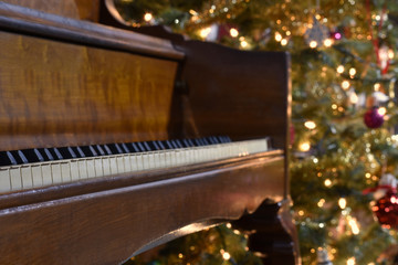 Fototapeta na wymiar a piano with a Christmas tree in the background