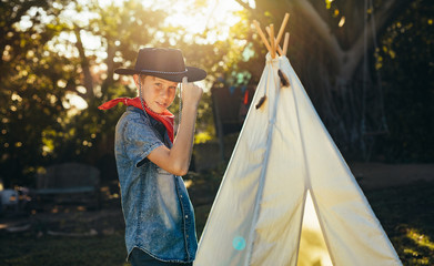 Little boy posing in cowboy hat in backyard © Jacob Lund