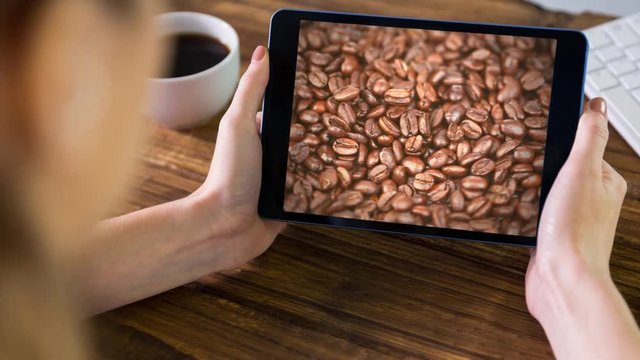 Woman using tablet with coffee beans