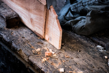 Hands of carpenter with chisel in the hands on the workbench in carpentry
