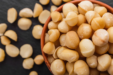 delicious macadamia nuts on a dark stone background