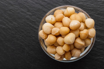 delicious macadamia nuts on a dark stone background