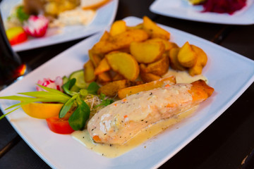 Image of salmon with sauce and potatoes