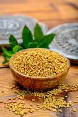 Bowl with fenugreek seeds close up, used for cooking and traditinal medicine, spices collection