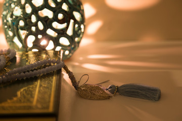 Koran and rosary beads on the white background with blue candle for Islamic concept. Holy book quran for Muslims holiday, Ramadan,blessed Friday message and three months.