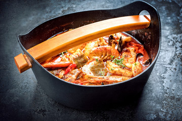 Traditionelle Südamerikanische Moqueca de Peixe mit Garnelen, Muscheln und Fisch als Draufsicht in einem Modern Design Gusstopf 