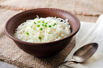 Sauerkraut with green onions in rustic bowl