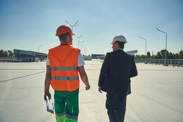 Back veiw of project manager and engineer are locating on building site