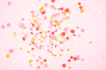 Colorful circle confetti on coralbackground. Festive bacground in trendy color. Living coral color of the year 2019.