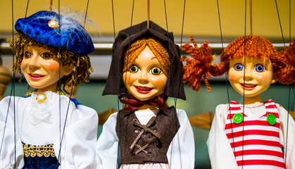 Row of traditional puppets - charming prince, young peasant and carefree girl
