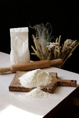 White flour for baking. Fine grinding, kitchen table, rolling pin, package. Recipe for traditional bread.