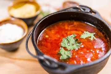 Red soup in black bowl on wooden table in a restaurant. Healthy food