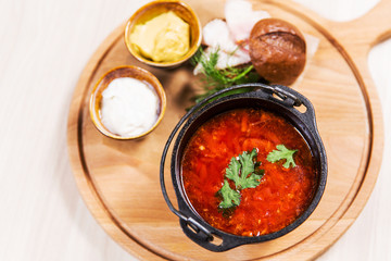 Red soup in black bowl on wooden table in a restaurant. Healthy food