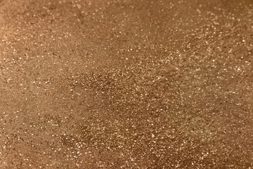 Fototapeta na wymiar Classic shiny bronze/copper glitter background with selective focus - glitter powder - abstract