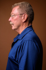 Profile view portrait of handsome senior man with mustache wearing eyeglasses