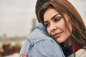Close up of cute couple in love is tenderly hugging on terrace. Copy space on left side