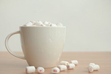 Fluffy white marshmallow in white cup on wooden table,Hot chocolate,Minimal.