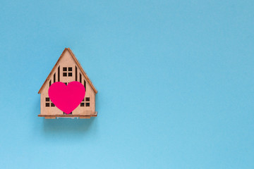 wooden house with heart concept of family, love in home, comfort, gift, valentine's day on pastel background