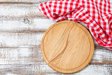cutting desk and red checkered wrinkled tablecloth on table, holiday concept
