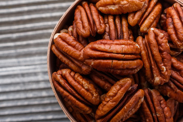 delicious pecan nuts on a rustic wooden background