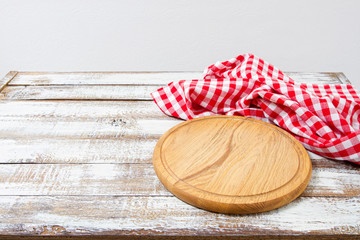 cutting desk and red checkered wrinkled tablecloth on table, holiday concept