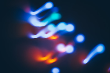 Colorful bokeh lights on black background. Holiday creative background.