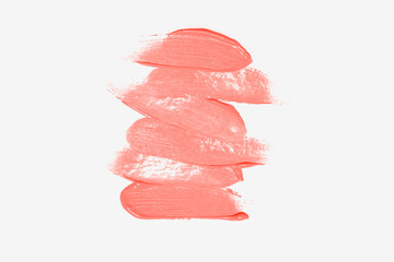 Foundation cream smear texture, isolated on white, colored in color of year 2019 Living Coral. Bright Macro color 16-1546
