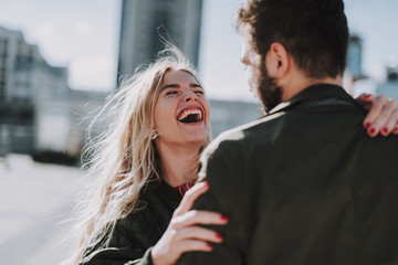 Cheerful young lady enjoying company of her boyfriend