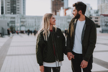 Beautiful couple holding hands while walking on the street