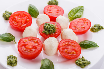 Caprese salad on a white acrylic background