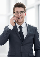 smiling young businessman talking on smartphone