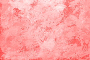 Living Coral color on abstract background or decorative texture of stucco wall, plaster. 