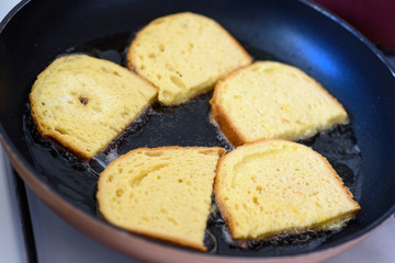Cooking french toast on frying pan. Close up fried bread in boiling oil on pan.