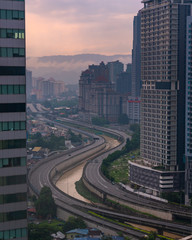 Smog and mist from recent rains create a moody atmosphere in the last light overlooking Kuala Lumpur