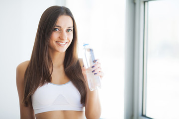 Healthy lifestyle. Beautiful fit young woman holding a bottle of water