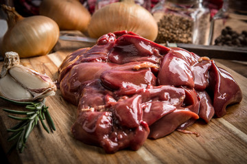 Raw chicken liver on cutting board.