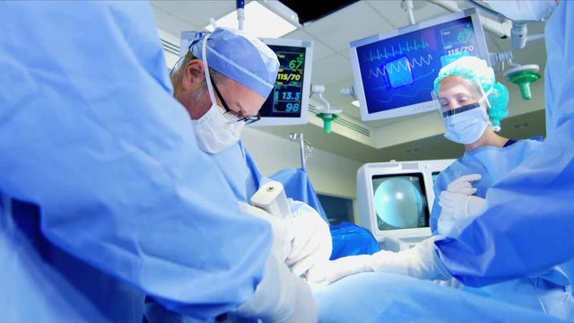 Medical hospital specialist team in scrubs training in the operating theater in Orthopaedic surgery using tools and modern electronic monitor imaging 