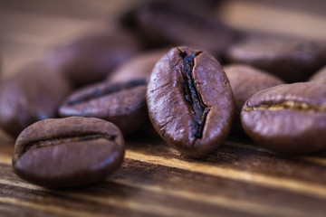 Roasted coffee beens on a wooden table, close up