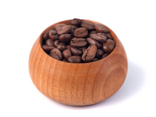 Roasted coffee beans in wooden cup on a white background
