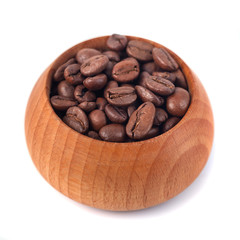 Roasted coffee beans in wooden cup on a white background