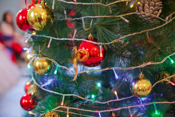 A Christmas ball hangs on the background of a clock. It's time for a new year. Multicolored glare...