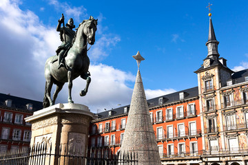 Madrid - Plaza Mayor, bronze statue of King Philip III, Christmas tree and painting facade.
